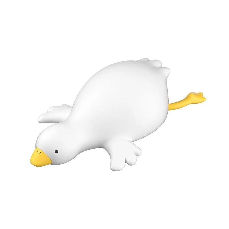 Big White Geese night light with warm white glow and silicone exterior on bedside table