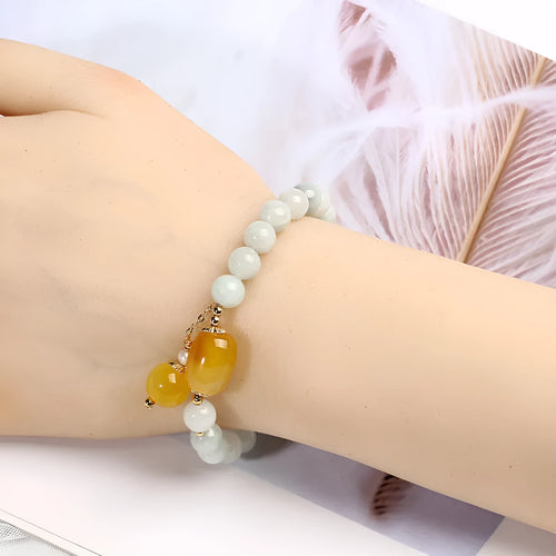Women's ethnic style geometric bracelet with hanging agate tassel and 14K gilded details.