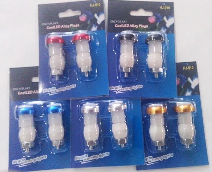 A pair of anodised aluminium bicycle handlebar safety lights in a choice of colours, showing the LED lens and mounting nut.