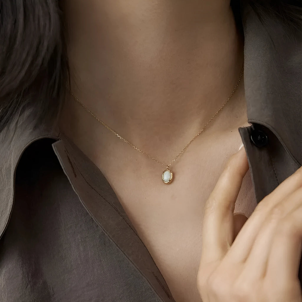 Simple geometric oval pendant necklace in gold plating on a silver chain.