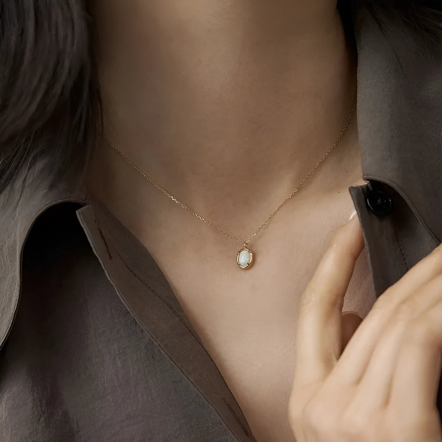Simple geometric oval pendant necklace in gold plating on a silver chain.