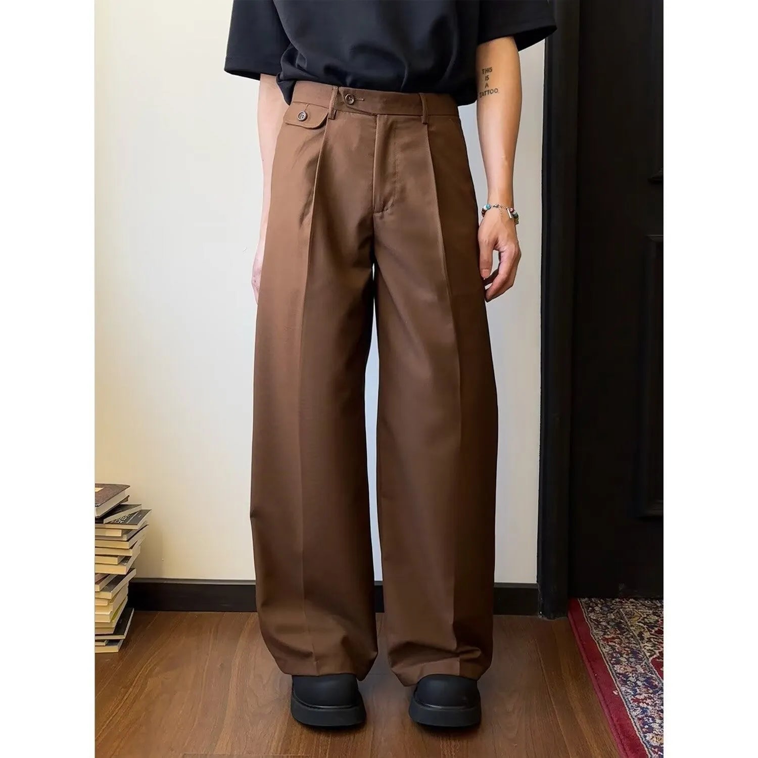 Men's straight-leg wide trousers in brown and black, showing loose fit and casual style.