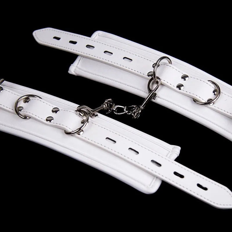 White PU sponge bondage sex toy set showing handcuffs, foot cuffs, and a neck scarf laid out.