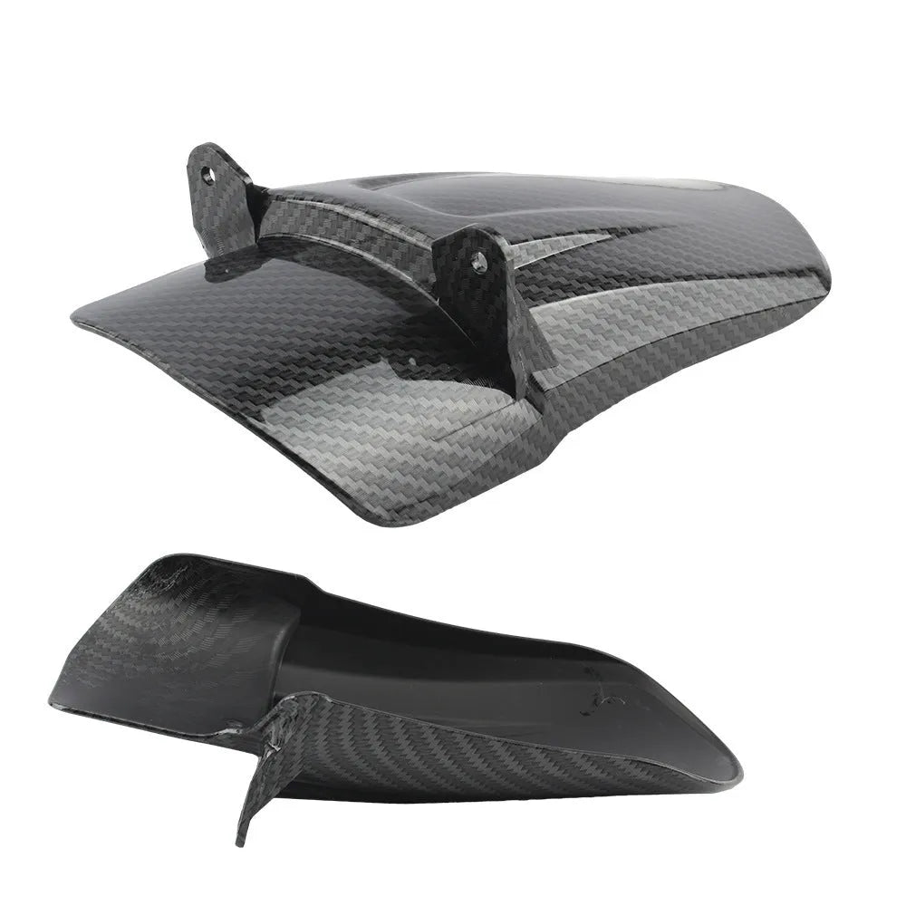 Carbon fibre rear shock absorber fender for a scrambling motorcycle.