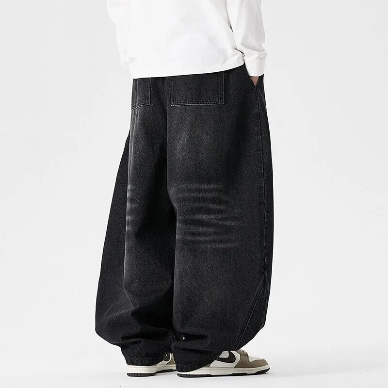 Men's plus-size light blue wide-leg baggy denim jeans on a hanger.
