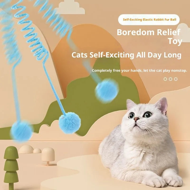 Blue cat toy with suction cup, spring rabbit fur ball, and retractable elastic rope on a door surface