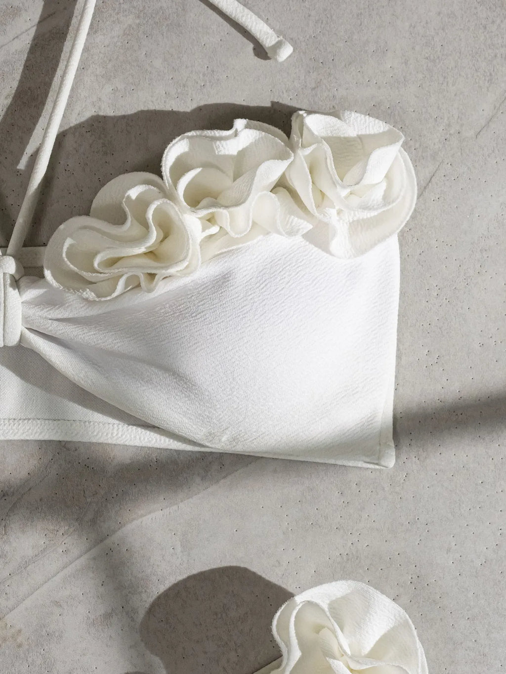 White halter swimsuit with three-dimensional floral lace-up front and split sides
