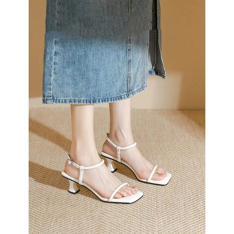 Black women's high heel sandals with a single buckle strap, square toe, and a chunky thick heel.