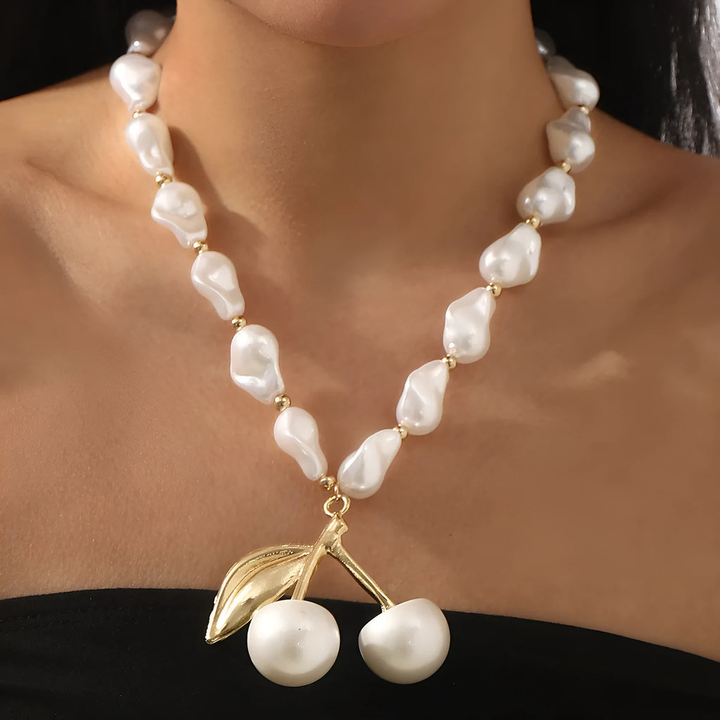 Gold fruit and geometric pendant necklace on a pearl chain, adjustable 51-60cm length.