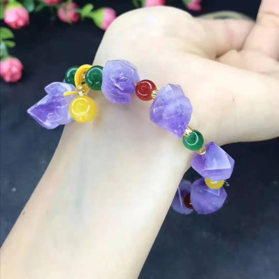 Women's natural amethyst bead bracelet with a fu character charm on a white background.