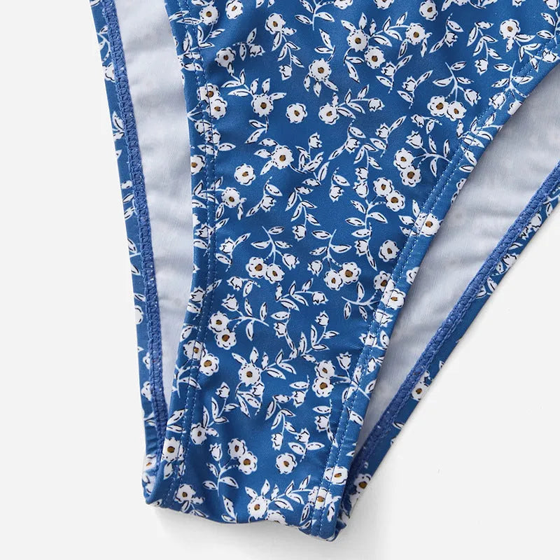 Blue three-piece swimsuit set with top and shorts on white background