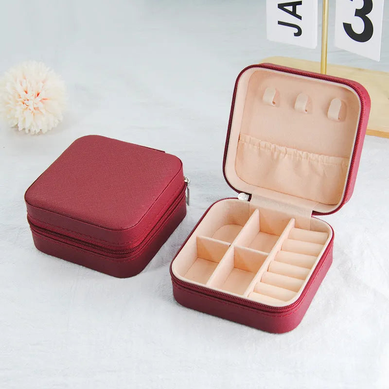 Small leather jewellery box in cross pattern, 10cm size, for earrings and rings, on a flat surface.