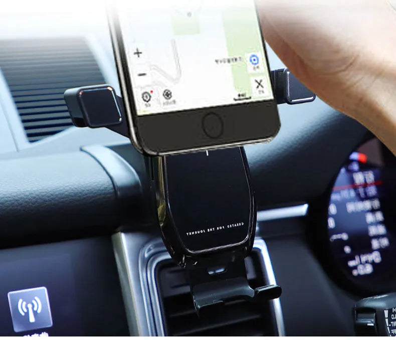 Gravity linkage car phone holder for Porsche in black alloy and carbon fibre, with phone mounted for navigation
