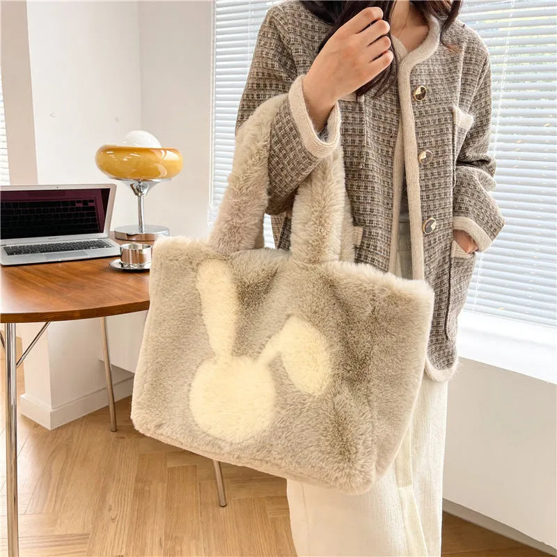 Soft beige plush tote bag with cartoon rabbit ears on the front, shown as a large capacity shoulder bag.