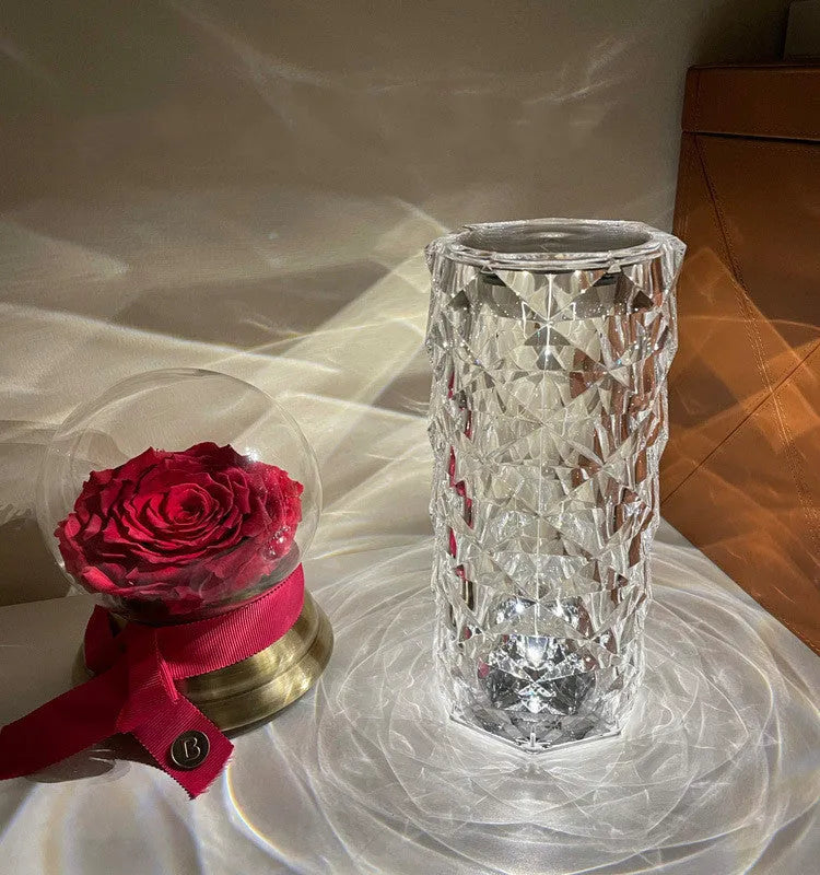 Modern acrylic rose LED table lamp with diamond base and touch control on wooden surface