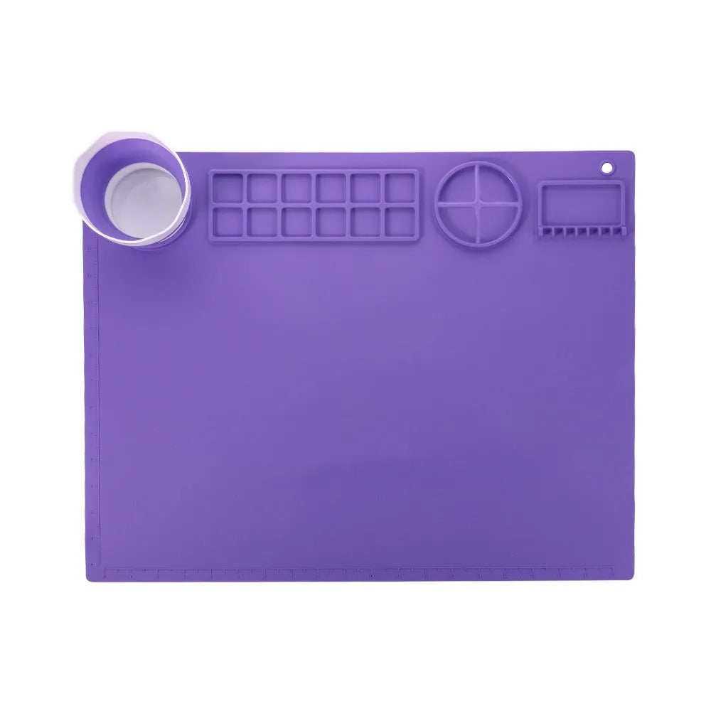 Light blue silicone painting mat with two moulded bowls for artists, size 50cm by 40cm.