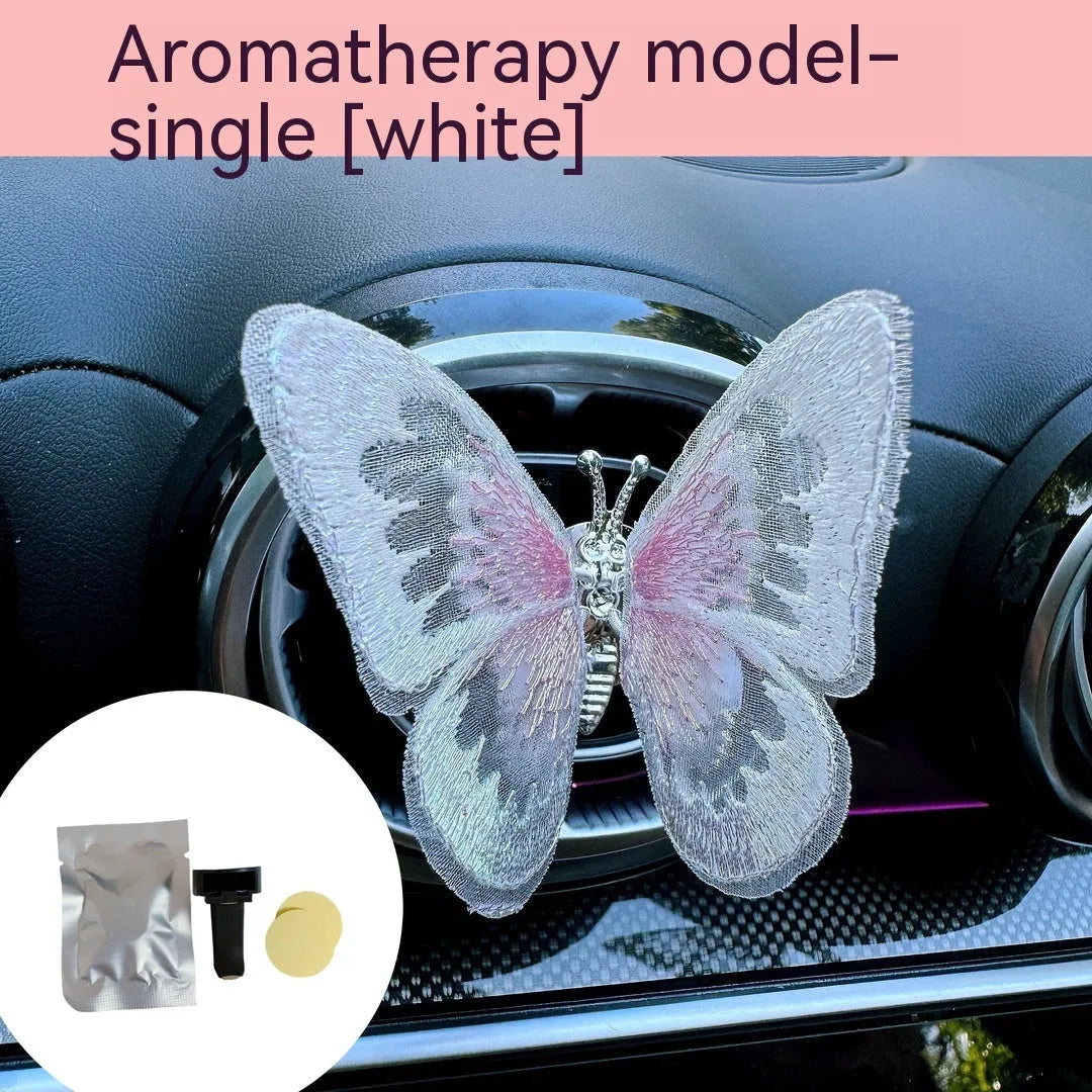 Fabric embroidered butterfly car air vent decoration in multiple colour options on a dashboard.