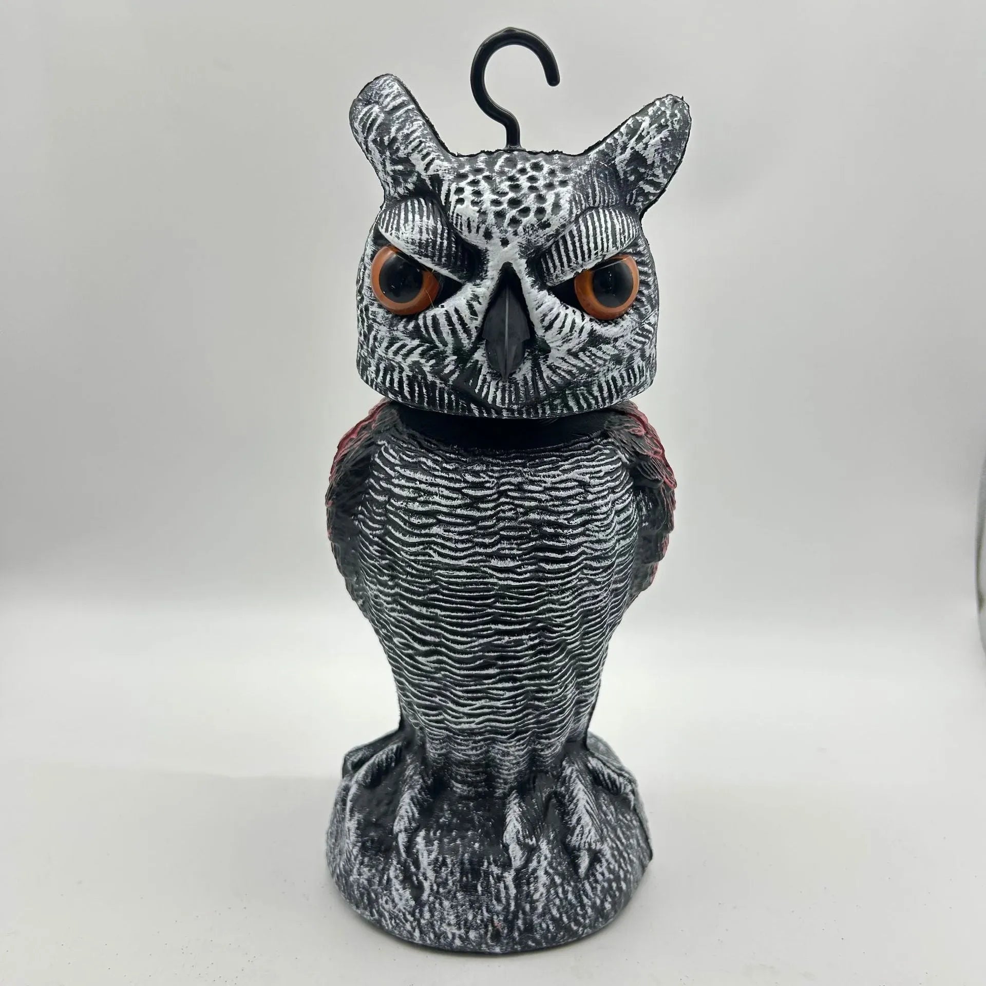 Artificial owl bird deterrent ornament with shaking head design in outdoor garden setting