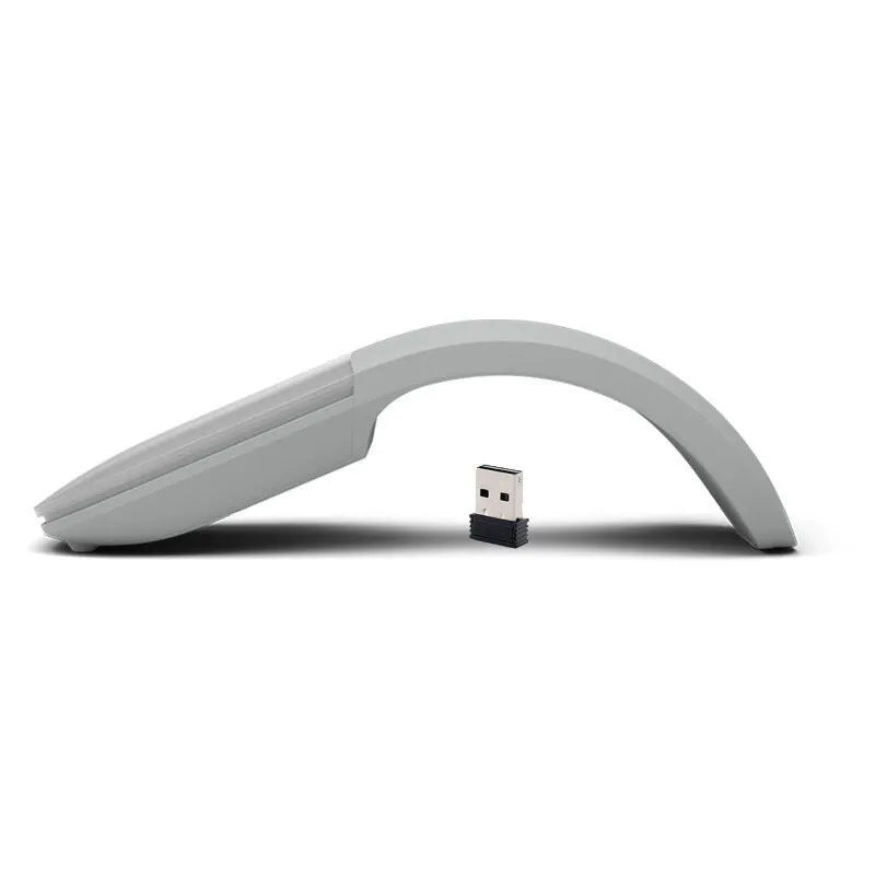 Black folding Bluetooth wireless mouse shown both folded and unfolded beside laptop