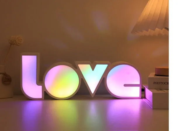 Rainbow style LED LOVE decorative table lamp with plastic shade on a table
