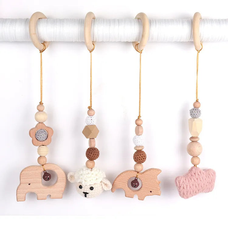 Beech wood baby rattle with animal pendants in orange, 28cm length, on white background