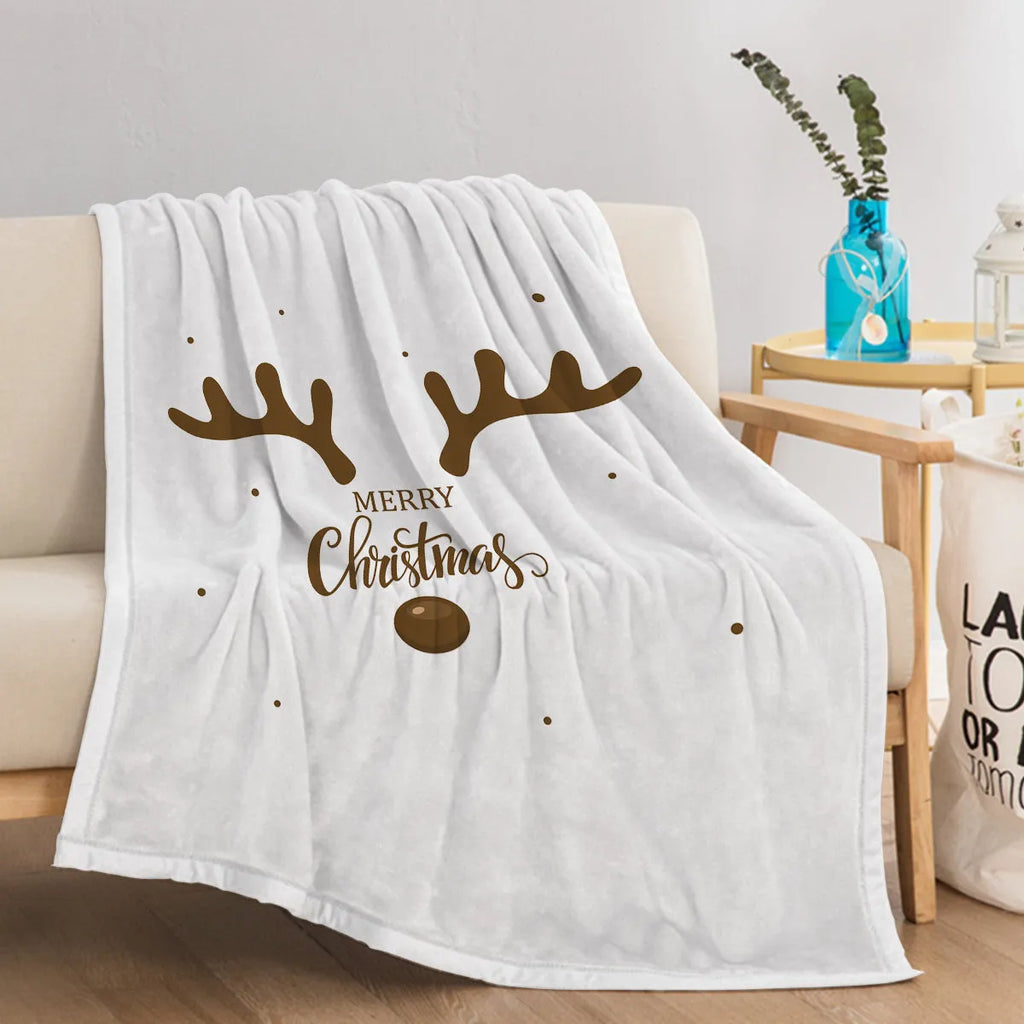 White flannel velvet deer antler pattern Christmas blanket on a sofa