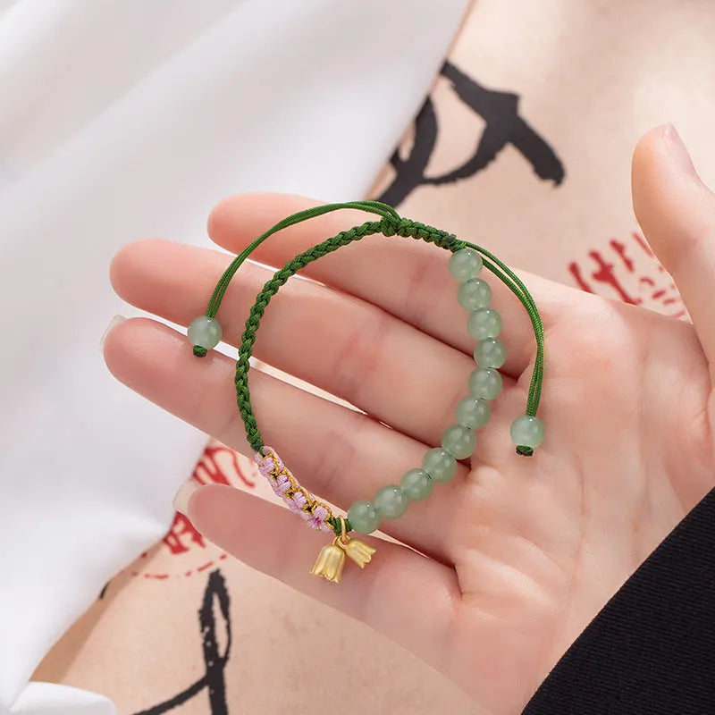 Hand woven red rope bracelet with floral decorative elements in national style design