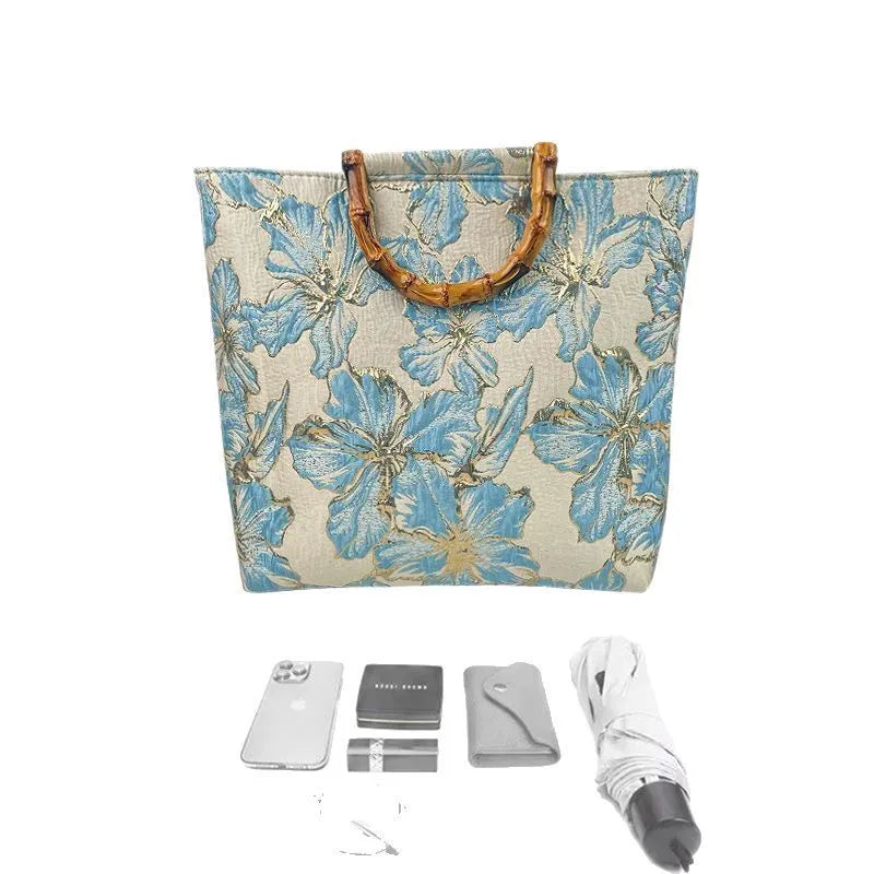 Women's light blue canvas shoulder bag with bronzing flower detail showing horizontal square shape and double straps