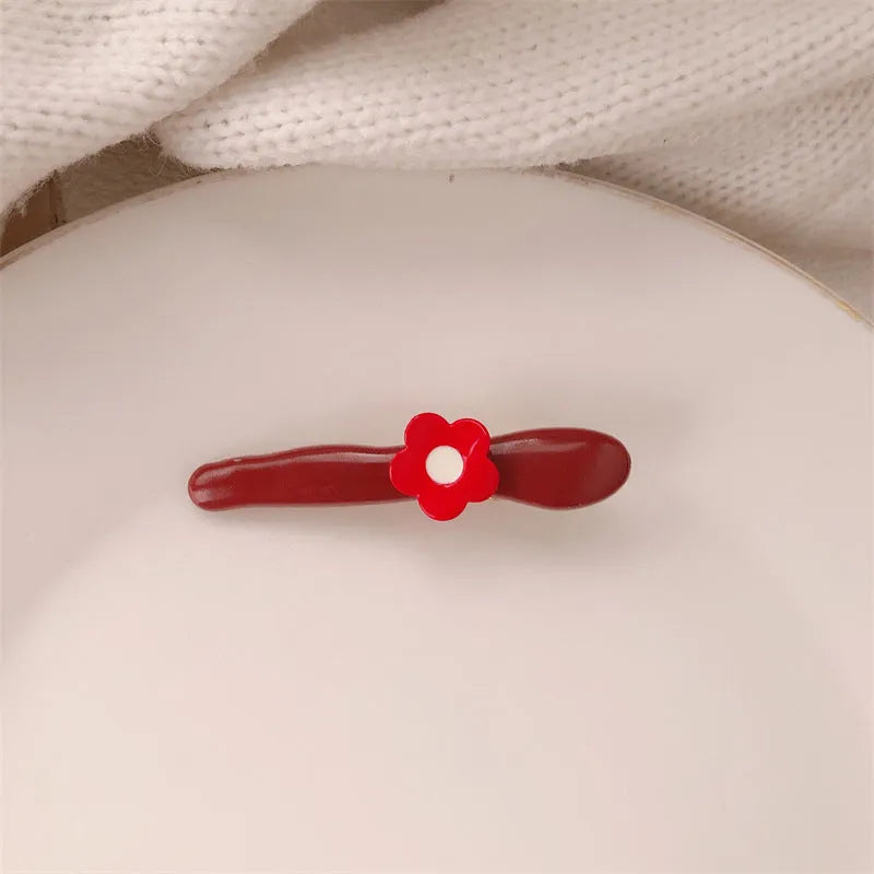 Red love heart-shaped plastic hair clip with retro dots and a willow leaf silhouette on a white background.