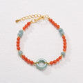 A woman's adjustable South Red Agate bracelet with 4mm beads and a safety buckle on a wrist.