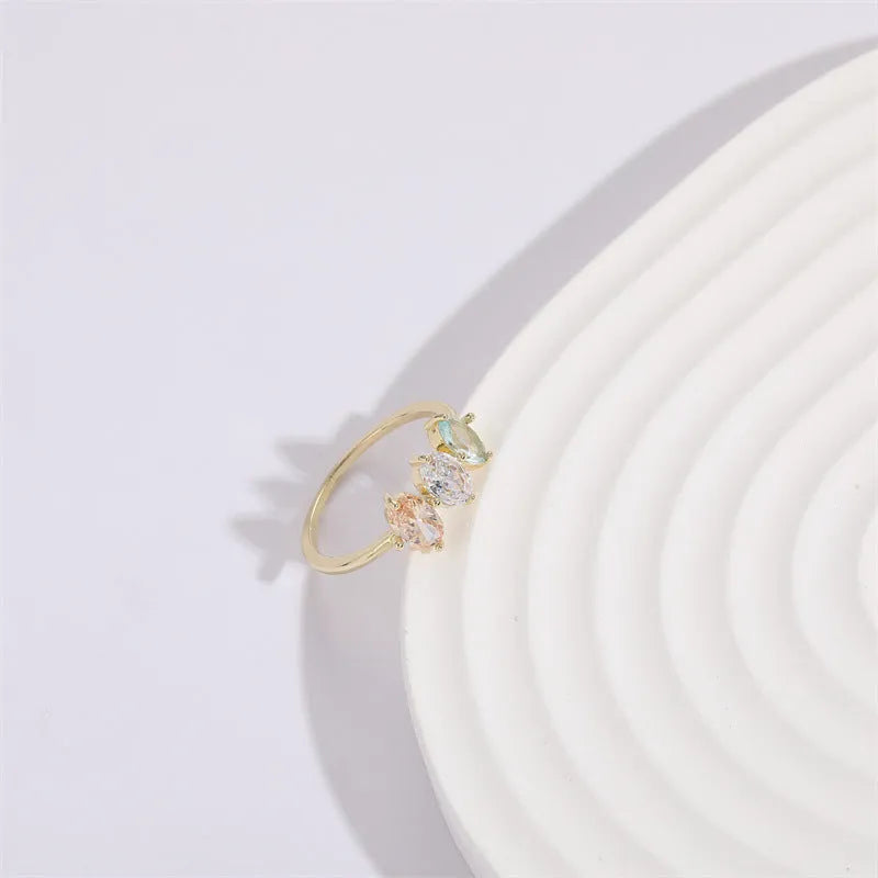 Geometric gold-colour women's ring with a triangular horse eye tricolour zircon stone.