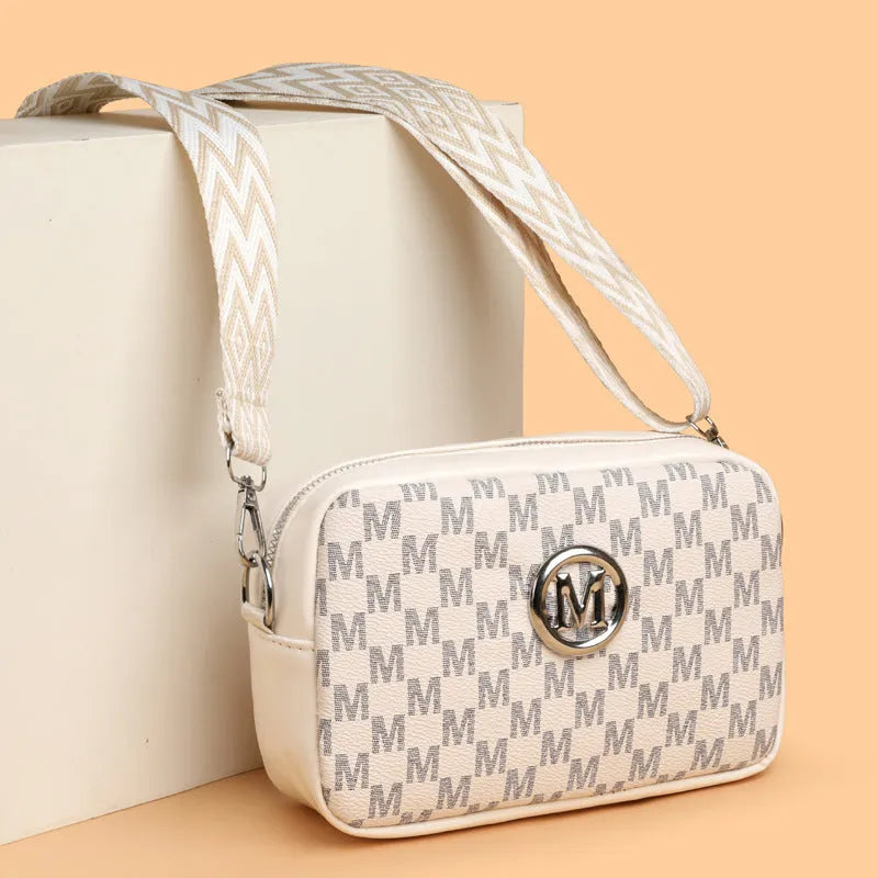 Black wide-strap crossbody bag made of PU leather, showing the three-dimensional outer pocket and adjustable shoulder strap.