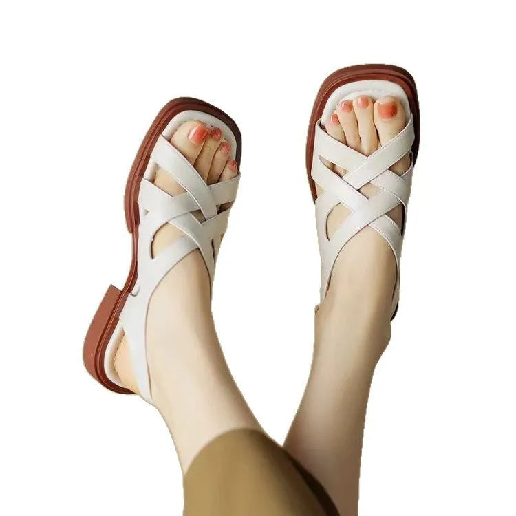 Women's glossy black patent leather beach sandals with a square toe and cross-belt design on a rubber sole.