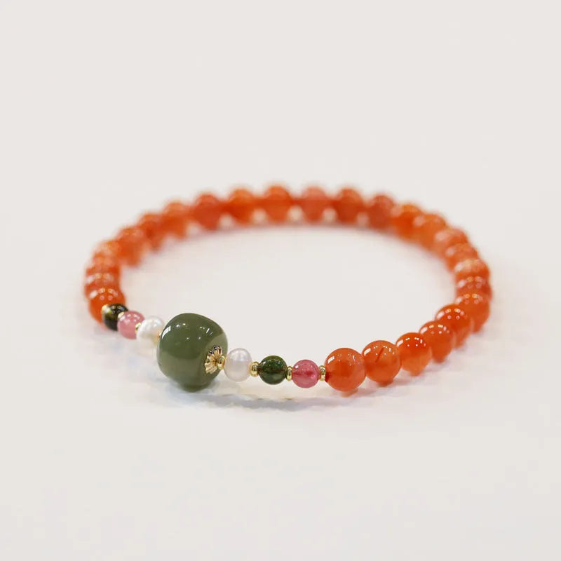 Women's bracelet made of round red South agate beads from Sichuan on a black elastic cord.