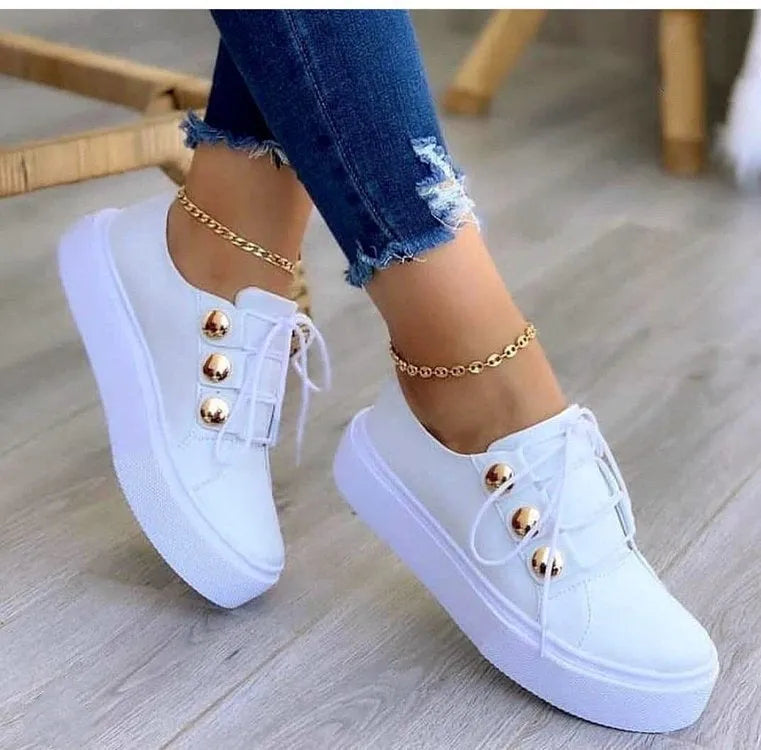 Women's white lace-up flats sneakers with round toe and silver rivet details on the low upper.
