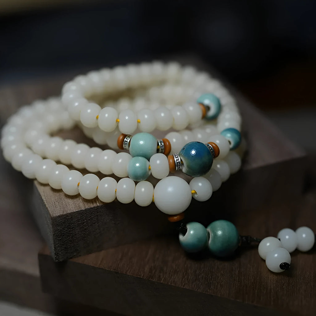 White jade bodhi root bracelet with 108 flat round beads in two sizes on wrist