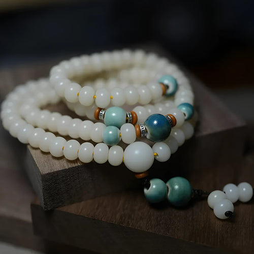 White jade bodhi root bracelet with 108 flat round beads in two sizes on wrist