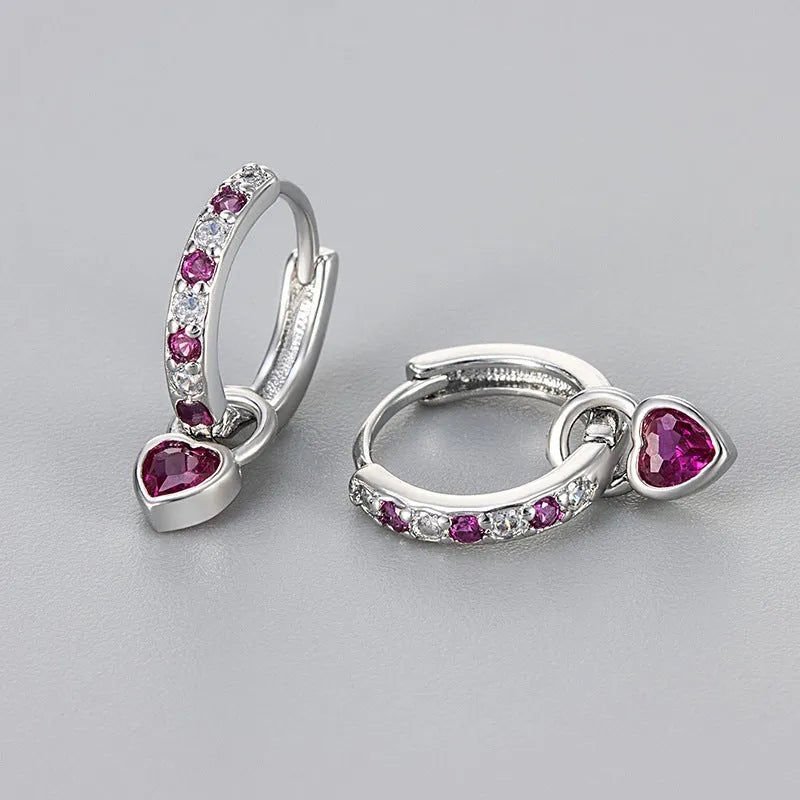 Gold colour heart-shaped clip earring with a central blue zircon stone on a white background.
