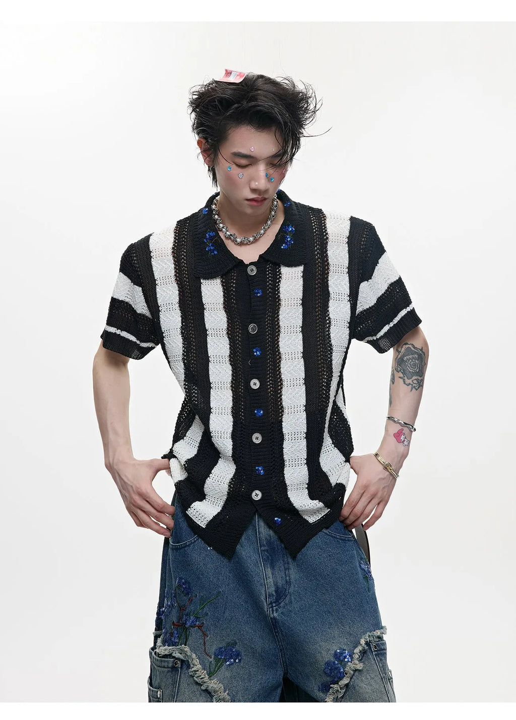 Man wearing a red and black patchwork striped retro knitted short-sleeved shirt in a loose fit.