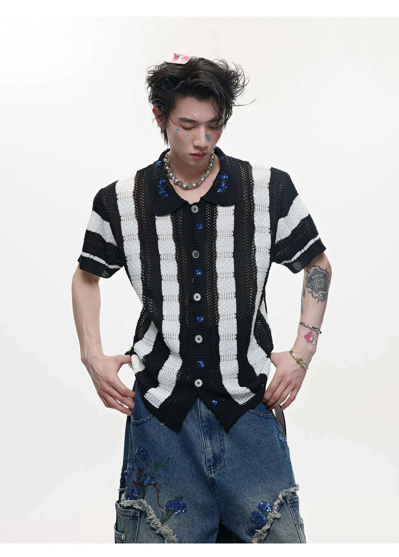 Man wearing a red and black patchwork striped retro knitted short-sleeved shirt in a loose fit.