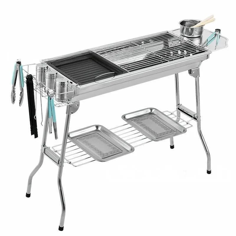 Large stainless steel folding portable barbecue oven with grill, shown outdoors.
