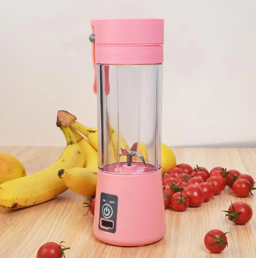 Pink mini USB electric fruit juicer with carrying rope on a kitchen countertop.