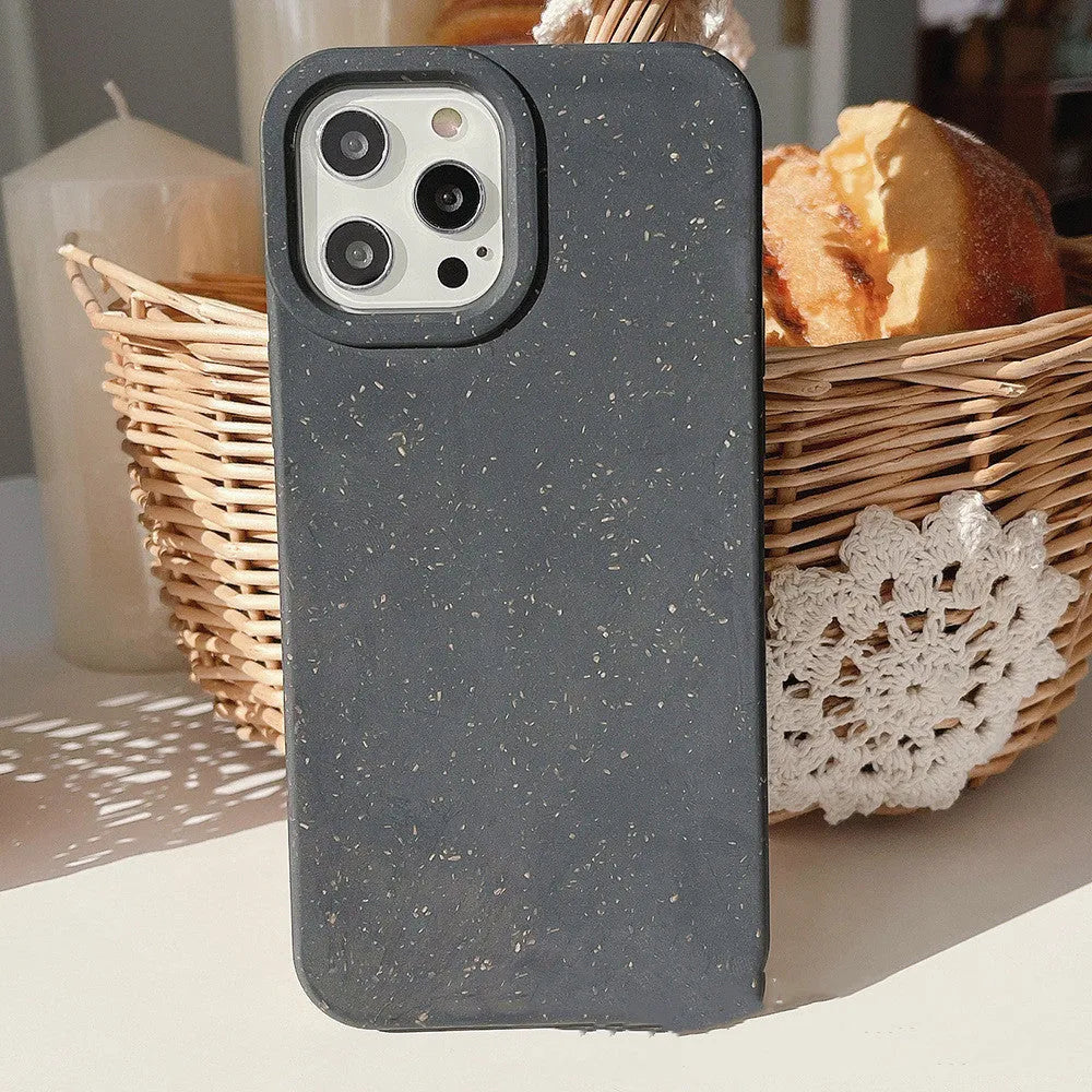 Degradable wheat straw phone case for Apple iPhone on a wooden surface.