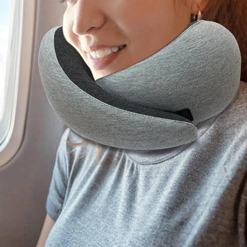 U-shaped memory foam travel neck pillow rolled up next to its carry bag, showing navy blue and grey colour options.