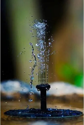 Black solar garden fountain pump with panel and four spray nozzles on grass