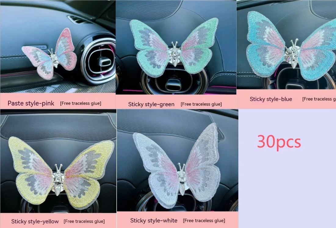 Fabric embroidered butterfly car air vent decoration in multiple colour options on a dashboard.