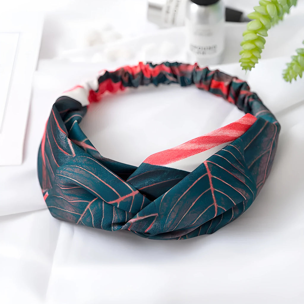 Red cloth women's headband with a banana leaf cross shaped hair decoration.