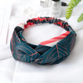 Red cloth women's headband with a banana leaf cross shaped hair decoration.