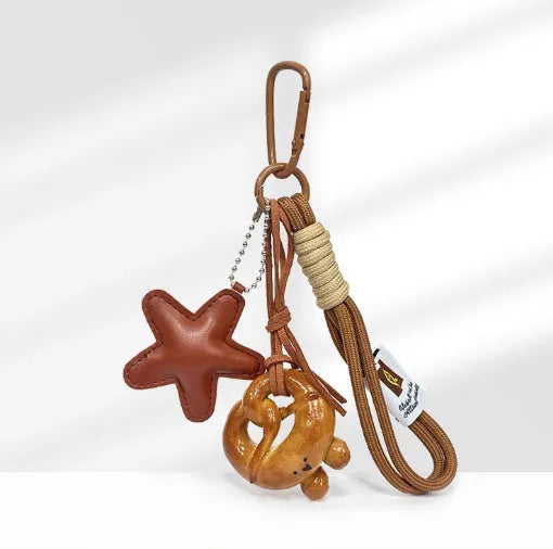 Handmade resin soda bread handbag pendant with baking varnish finish and brown carrying strap.