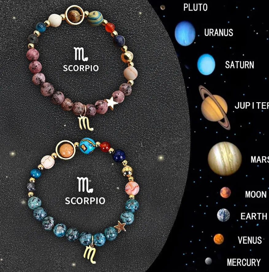Two natural stone beaded bracelets with zodiac charms on a table.